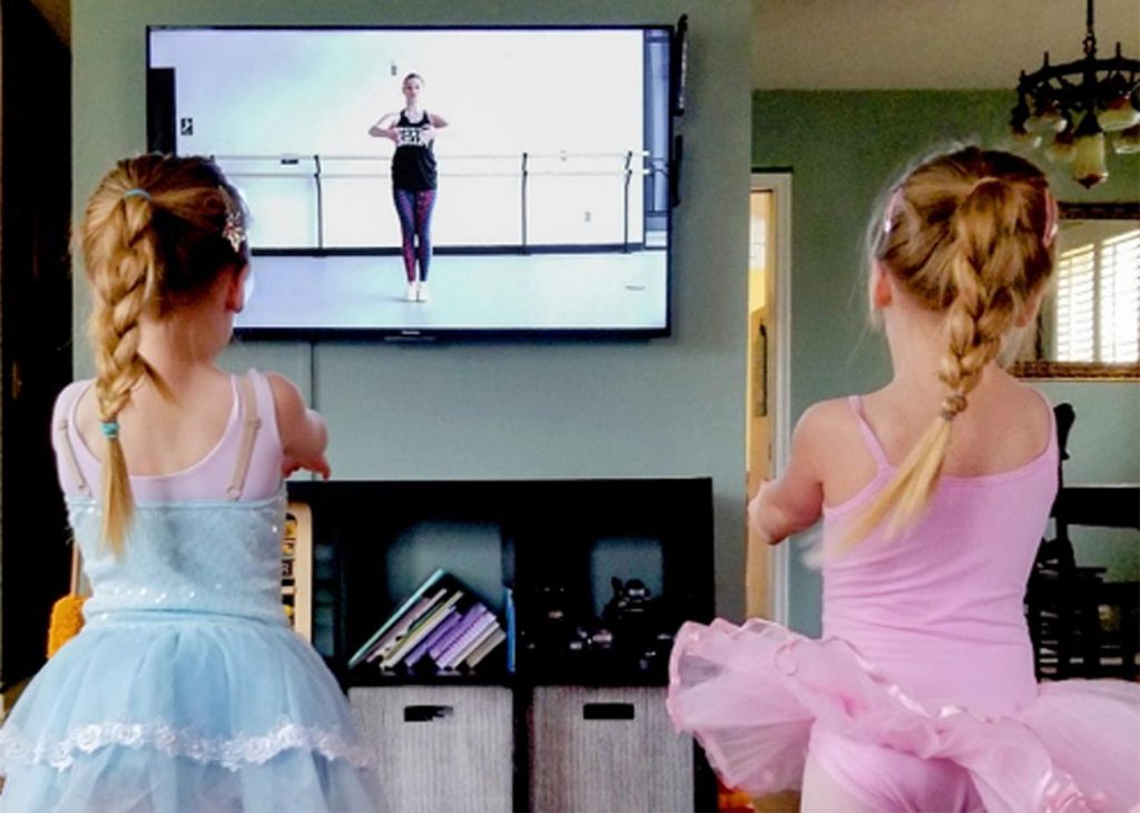 Two young dancers participate in American Midwest Ballet's online dance classes from their living room.